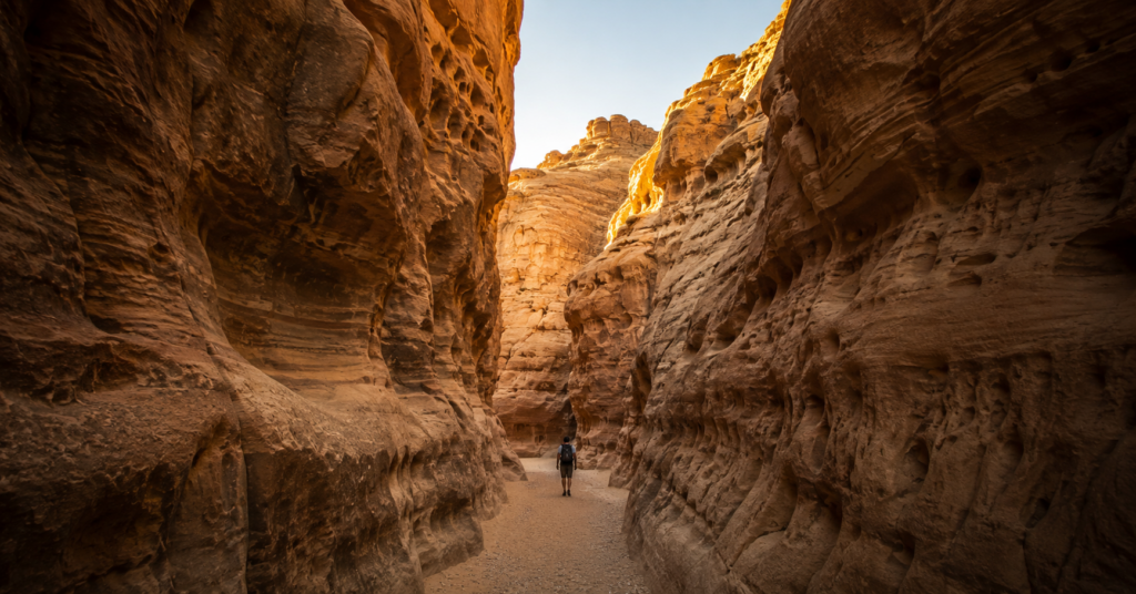Narrow desert canyon with hiker